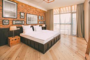 第比利斯Kisi Boutique Hotel的一间卧室设有一张大床和砖墙