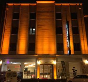 科尼亚萨法皇家博物馆酒店的一座建筑,在晚上前方有标志
