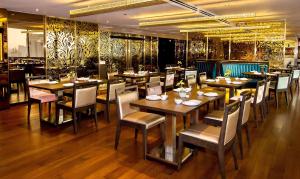 曼谷察殿恩博利豪华酒店的一间设有木桌和椅子的餐厅