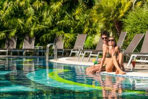 加尔达湖滨佛洛拉帕克酒店的坐在游泳池冲浪板上的男女