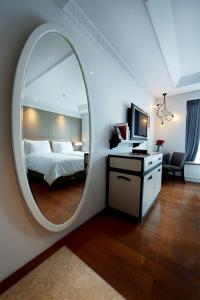万隆De Paviljoen Bandung的一间卧室配有大圆镜子和一张床