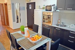 萨格勒布托尼公寓的厨房配有一张桌子,上面放着一碗水果