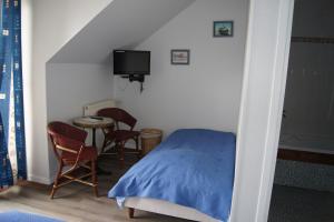 勒克罗图瓦奥克斯多利斯基恩酒店的卧室配有一张床和一张桌子及椅子