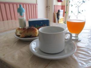 马德普拉塔普尔拉中央酒店的一杯咖啡和一盘食物以及一杯橙汁