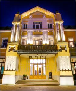 莱维采Hotel Lev的黄色的建筑,设有门廊和门