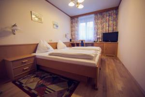 格拉茨博坎宾馆的一间卧室配有一张床和一台电视