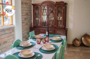 Hacienda ZuletaSanta Rosa de Lima Hostal Zuleta的一张桌子、绿色椅子和木制橱柜