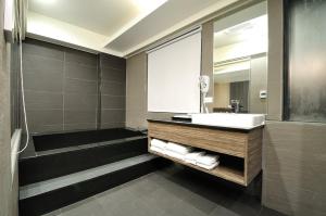 罗东镇山水商务饭店的一间带水槽、淋浴和镜子的浴室