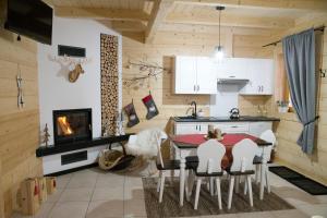 MizernaDomki letniskowe całoroczne的厨房配有桌椅和壁炉。