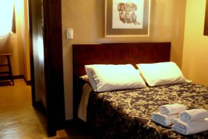 马德普拉塔Posta Chimango, Cabañas frente al Golf Los Acantilados的一间卧室配有一张床,床上配有两张折叠毛巾