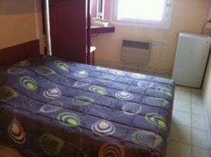 罗什福尔-迪加尔亚维农罗什福尔柠檬酒店的一间小卧室,卧室内配有一张床铺