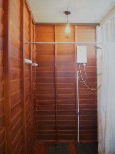 乌泰他尼府乌泰他尼乌帕伊旅舍的配有木墙的客房内的淋浴