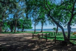 勒莫尔尼Maison Belle Vue的海滩前的公园里种有树木和长凳