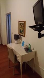 切塞纳蒂科拉伯罗多酒店的一张带椅子的白色桌子和墙上的电视