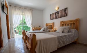 Alozaina桑戈塞拉德拉斯涅韦斯旅舍的一间卧室设有两张床和窗户。