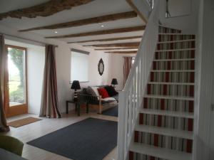 RunanGites du Manoir的一间带楼梯和沙发的客厅