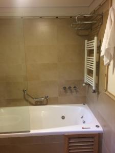 圣马丁德洛斯Golf y Polo Apartment的一间带浴缸和玻璃淋浴的浴室