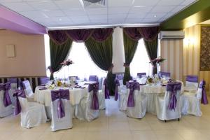 布加勒斯特拉吉尔酒店的宴会厅配有白色桌子和紫色弓
