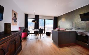 LavantAntonius Natur Apartment - kinderfreie Unterkunft的厨房以及带桌椅的起居室。