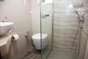 马莱迈阳光套房酒店的带淋浴、卫生间和盥洗盆的浴室