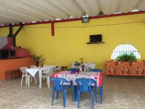 卡拉瓜塔图巴Suítes Recanto Renascer的配有桌椅的房间和黄色的墙壁