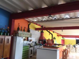 卡拉瓜塔图巴Suítes Recanto Renascer的厨房配有冰箱和桌椅