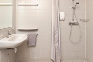 WinsumHotel Marenland Winsum的带淋浴和盥洗盆的白色浴室