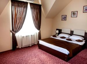 卡缅斯克-沙赫京斯基Art Hotel的一间卧室设有一张大床和一个大窗户