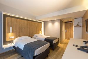 卢布尔雅那M酒店的酒店客房配有两张床和一张书桌