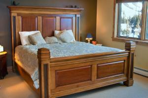 大天山村Twin Lift Lodge的卧室设有一张大型木床和窗户
