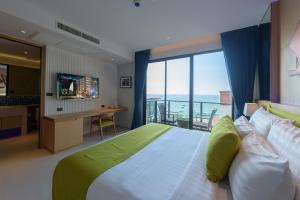 芭堤雅市中心Z10深蓝酒店的一间卧室设有一张大床和大窗户