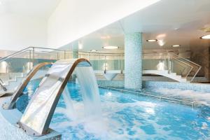 Cedzyna乌洛捷斯科酒店的一个带水滑梯的室内游泳池