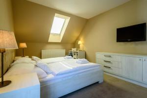 日利纳中央公园酒店的卧室配有一张白色大床和一台平面电视。