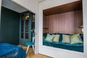 鲁瓦扬Studio Royan的一间卧室配有一张床和一张蓝色的沙发