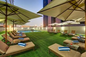 迪拜皇家欧陆酒店的酒店庭院设有躺椅和遮阳伞