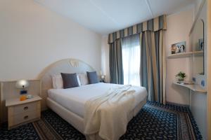 帕尔马公爵别墅CDH酒店的一间设有大床和窗户的酒店客房