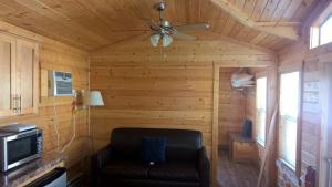 NicolausLake Minden Camping Resort Cottage 1的带沙发和吊扇的客厅