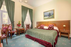 布拉格绿花园酒店的酒店客房带一张床、一张桌子和椅子
