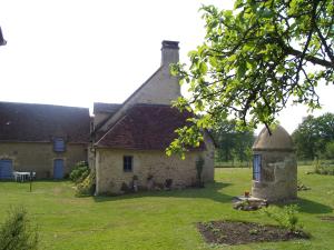 贝莱姆Maison d'Hôtes Les Après的一座老石头房子,在院子里有塔