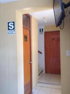 伊察Hostal La Estancia的大楼的走廊,带门和电视