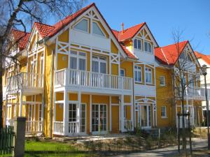 奥斯赛拜-屈隆斯博恩Uns Strandhus的黄色和白色的房子,有橙色的屋顶