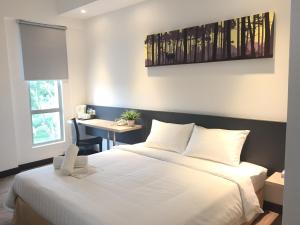 居林居林富勒酒店的卧室配有一张白色大床和一张书桌