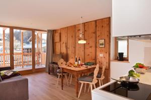 圣坎迪朵Residence Simml & Schlosser的一间厨房和带木墙的用餐室