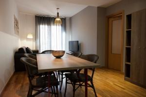 巴塞罗那MH格拉西亚公寓的客厅设有餐桌和椅子