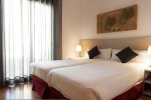 巴塞罗那MH格拉西亚公寓的卧室设有一张大白色的床和大窗户
