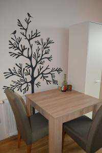 萨拉热窝Studio Apartment Ena S的餐桌,墙上挂着树 ⁇ 