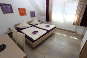 摩泽尔河畔的泽尔罗梅尔巴德旅馆的一间小卧室,配有两张床和窗户