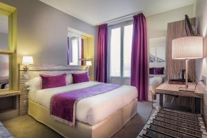 巴黎玛索里耶剧院酒店的酒店客房配有一张带紫色枕头的大床
