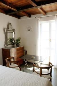 斯培西亚洛堪达特拉蒙蒂酒店的一间卧室配有书桌、桌子和窗户。