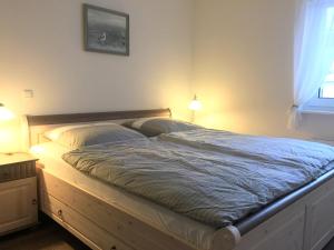 瓦尔内明德Apartment Warnemünde 19的一间卧室配有一张带两个枕头的木床
